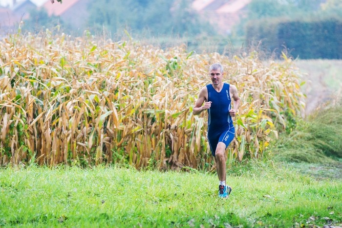 Man running in a field besides crops