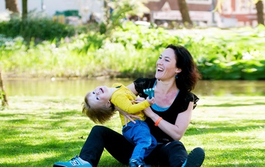 Woman carrying her child in a park