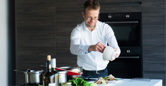 Man with glasses cooking in his kitchen