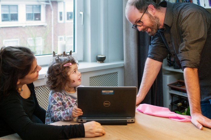 Young girl showing a man her mother's laptop