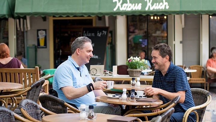 Man having lunch with another man at a cafe
