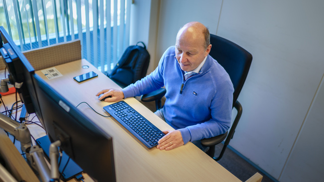 Medewerker zit achter een bureau