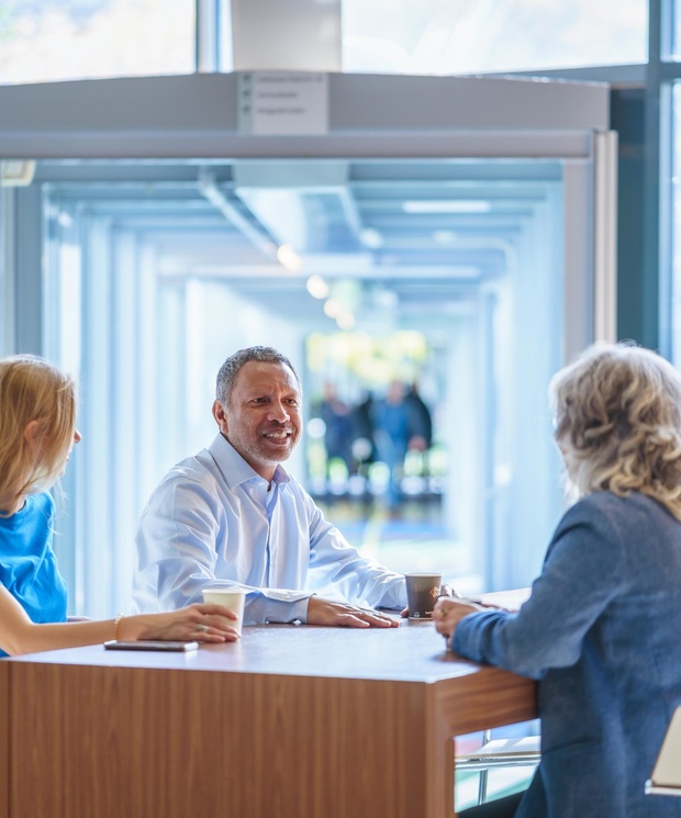 Drie collega's overleggen aan een tafel