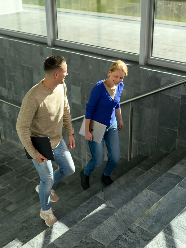 Twee medewerkers lopen de trap op