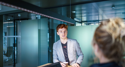 Jonge man in gesprek met collega