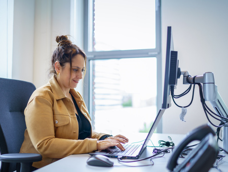 Medewerker zit te werken op de computer aan een bureau