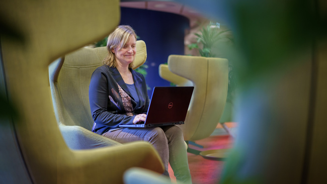 Marijke, adviseur AO/IC zit op een stoel met haar laptop