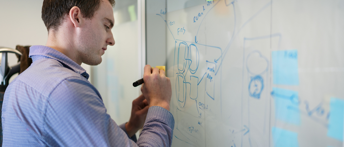 man schrijft iets op een whiteboard