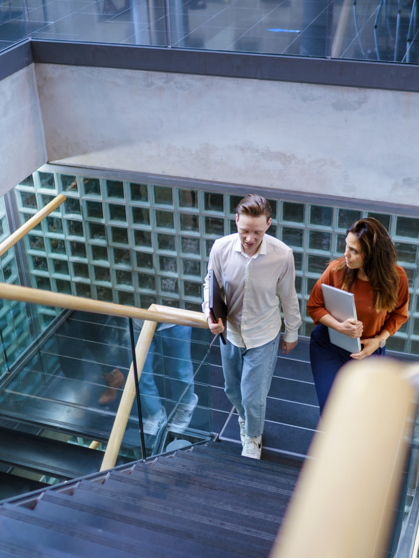 Twee collega's lopen de trap op