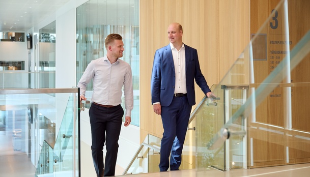 Twee medewerkers lopen de trap op