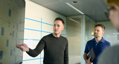 Een medewerker legt iets uit aan andere medewerkers