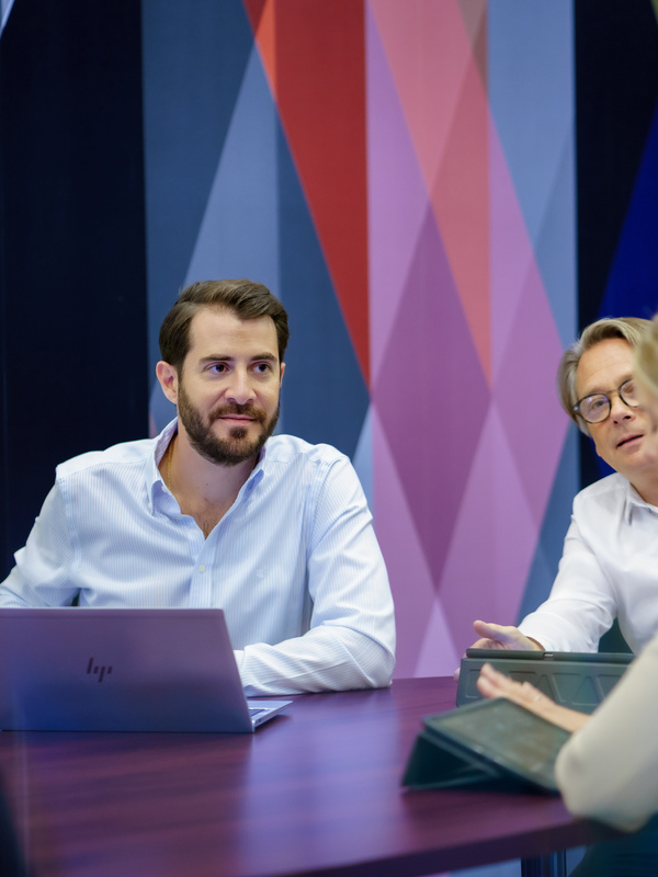 Medewerkers zitten aan een tafel