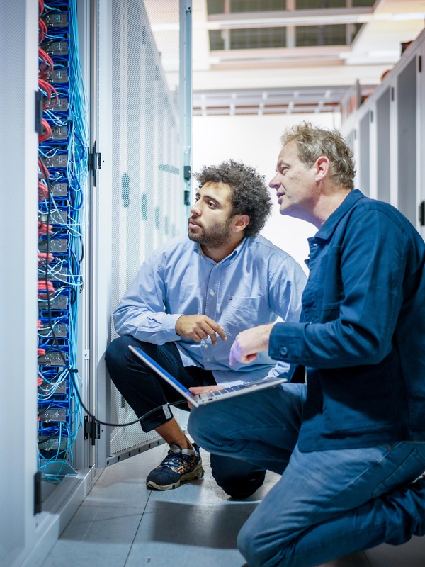 Twee medewerkers kijken samen naar een computerkast