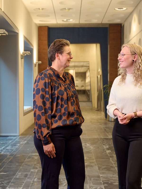 Medewerkers lopen door de gang