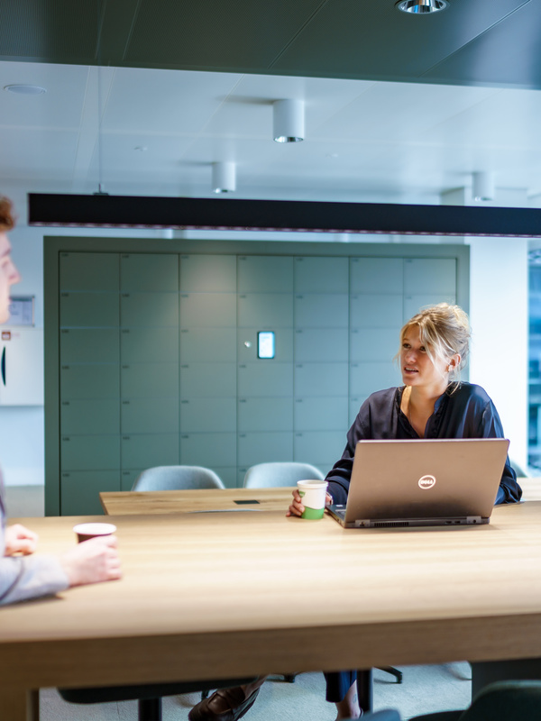 Twee medewerkers zijn met elkaar in gesprek
