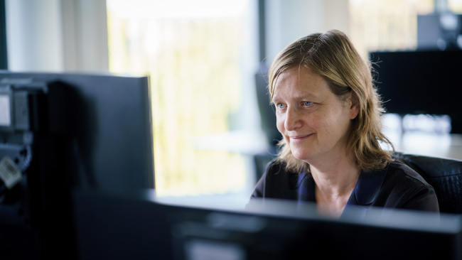 Marijke, adviseur AO/IC zit aan haar bureau, aan het werk op een computer