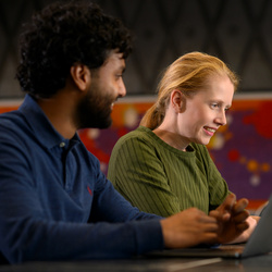 Twee medewerkers die achter hun laptop zitten