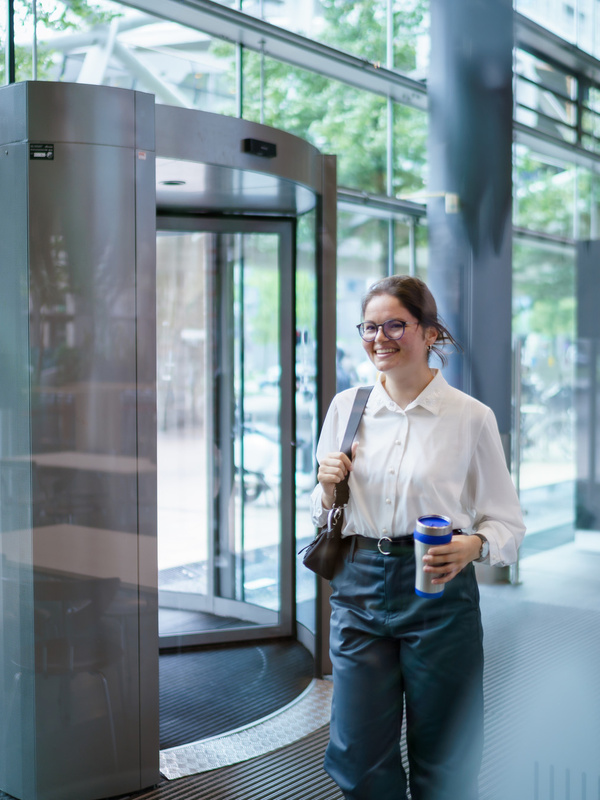 Een medewerker loopt door het pand met een beker in haar hand