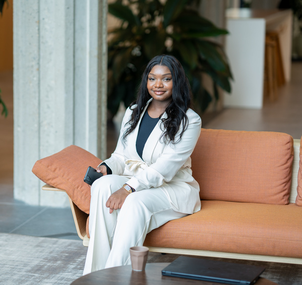 Werknemer zit op bank met telefoon op kantoor