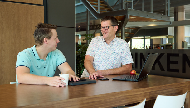 Twee werknemers staan aan een statafel
