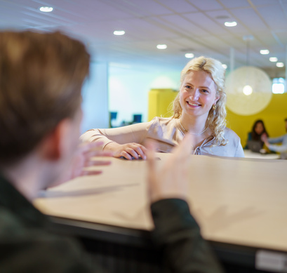 Twee medewerkers zijn in gesprek met elkaar
