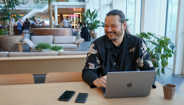 Medewerker zit aan een tafel met zijn laptop