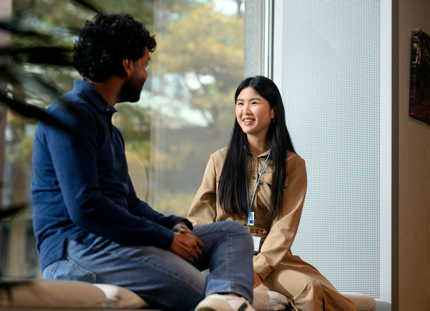 Twee medewerkers zitten op een bankje
