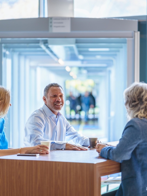 Drie collega's overleggen aan een tafel