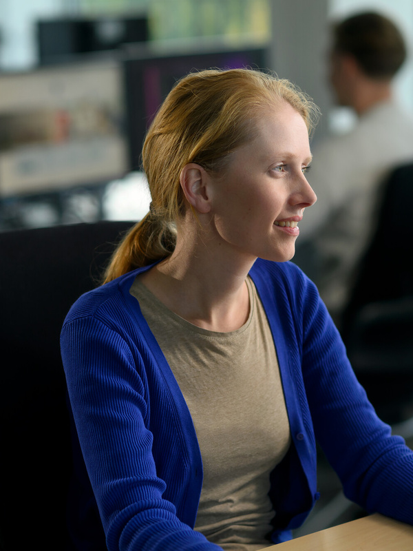 Medewerker zit aan een bureau achter haar computer