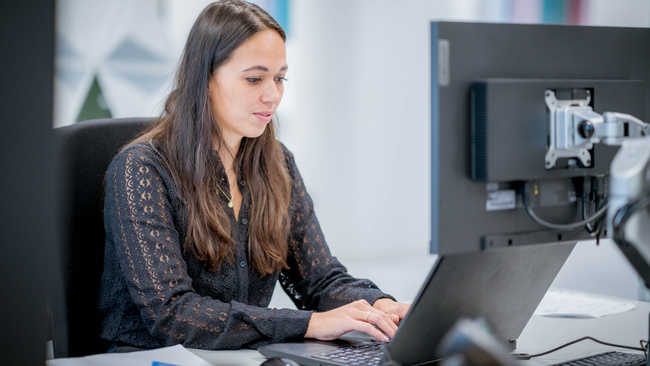 Vrouw typt op het toetsenbord van de computer