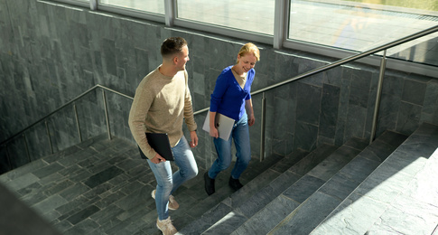 Twee medewerkers lopen de trap op