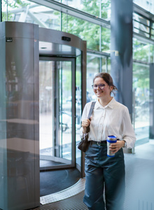 Een medewerker loopt door het pand met een beker in haar hand