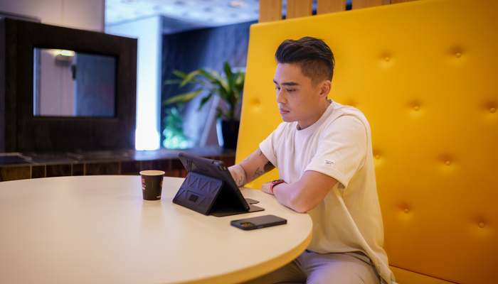 Medewerker zit op een bank met tablet