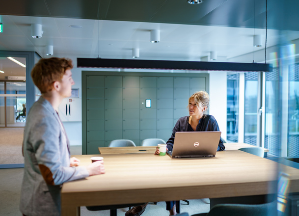 Twee medewerkers zijn met elkaar in gesprek
