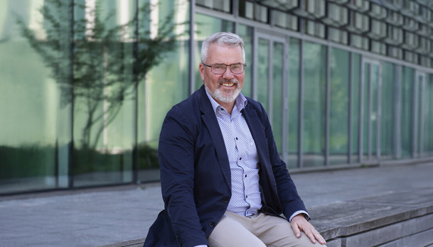 Medewerker zit op bank buiten voor Rijksgebouw