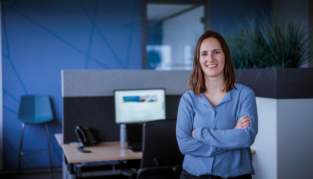 Medewerker Manon staat voor haar bureau