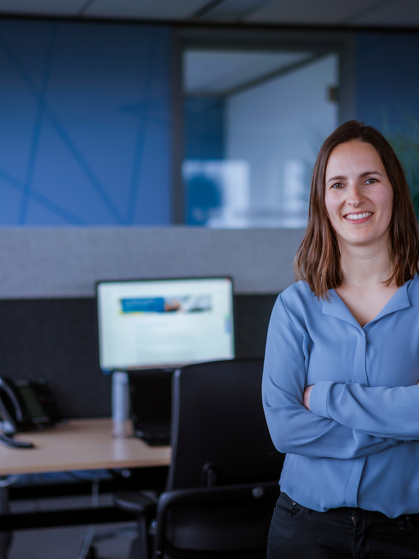 Medewerker Manon staat voor haar bureau