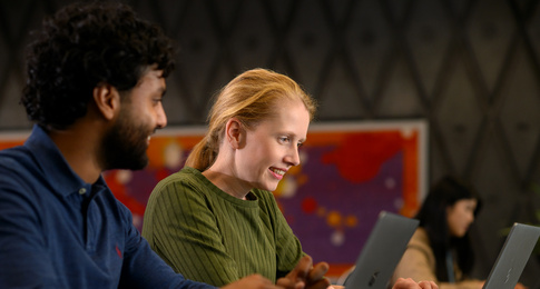 Twee medewerkers die achter hun laptop zitten