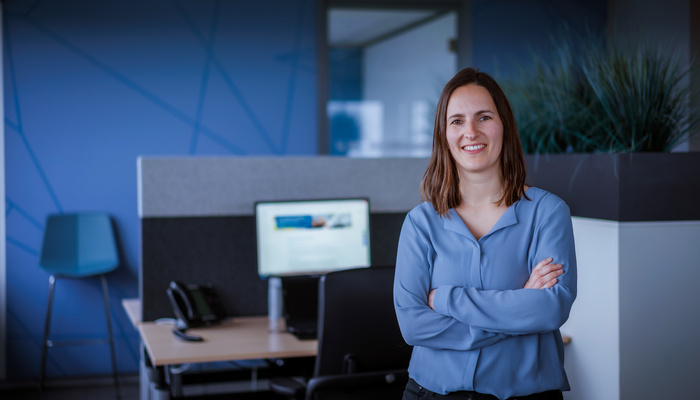 Medewerker Manon staat voor haar bureau