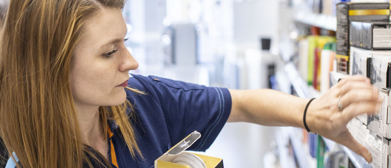 Image d’une employée d’Action réapprovisionnant le stock