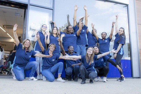 Un groupe d’employés d’Action enthousiastes devant un magasin Action