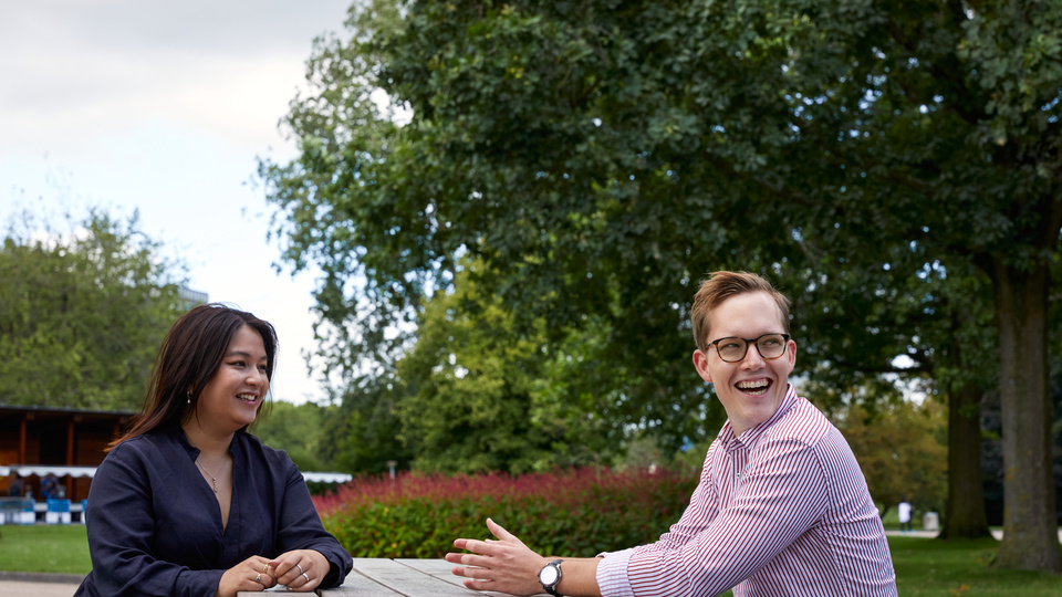 A picture of a woman and a man sitting on the bench.