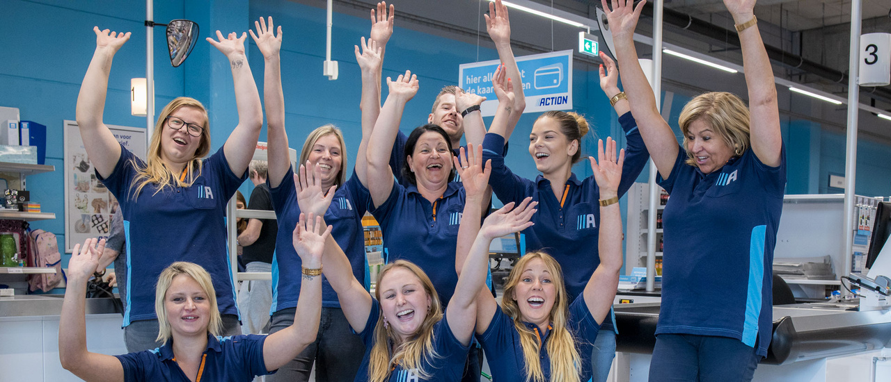 Groep van enthousiaste Action medewerkers in een Action winkel