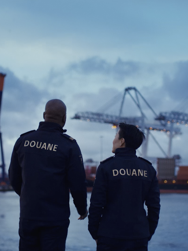 Twee medewerkers in uniform staan in de haven
