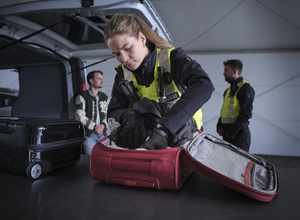 Medewerker controleert een koffer