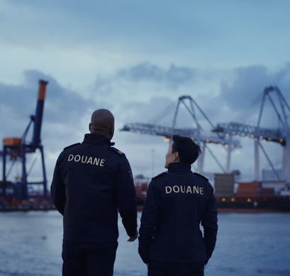 Twee medewerkers in uniform staan in de haven