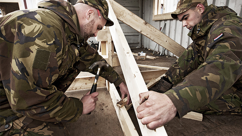 Soldaten timmeren aan een houten frame
