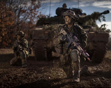 Infanteristen wachten voor een tank