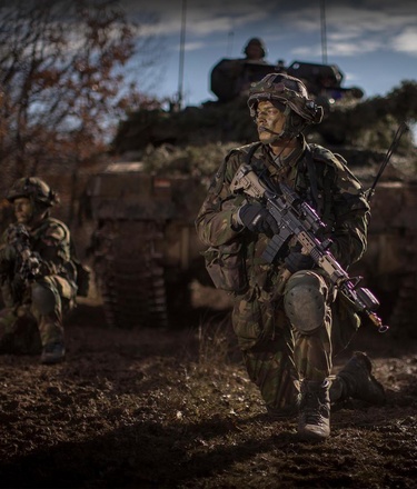 Infanteristen wachten voor een tank
