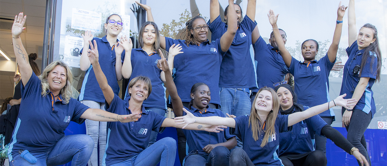 Un groupe d’employés d’Action enthousiastes devant un magasin Action